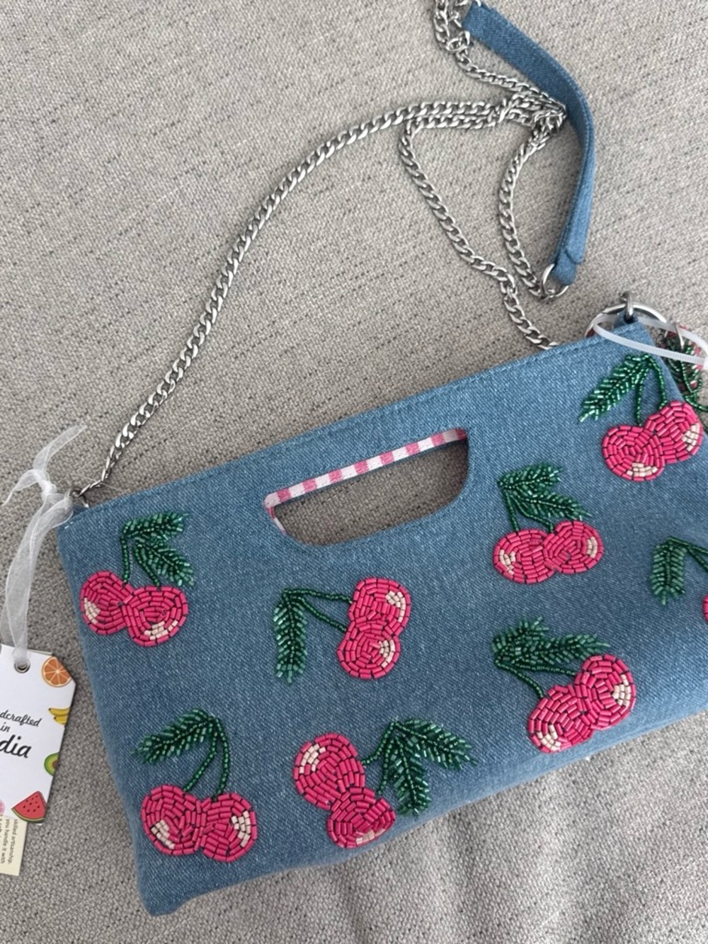 Blue denim handbag with pink cherry embroidery and green stems